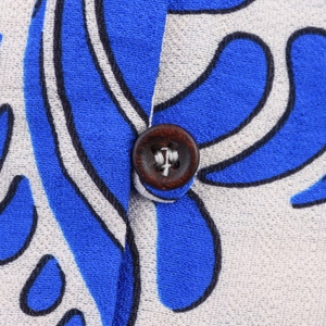 Detailed macro view of the natural wooden button on blue floral printed cotton fabric