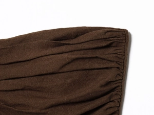 Detailed macro view of deep brown ruched fabric texture and fine stitching craft