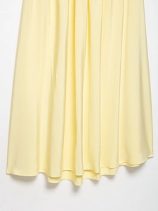 Detail shot of pale yellow pleated chiffon fabric showing natural drape and texture