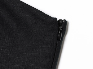 Detail of high-quality invisible zipper on a black mini dress with smooth fabric texture