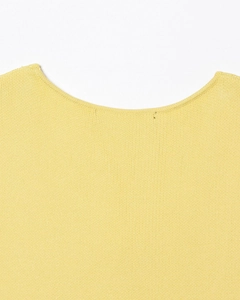 Détail d'une robe sans manches en maille fine jaune gingembre avec une encolure ronde