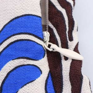 Macro view of woven pillow cover showing invisible zipper and mixed print fabric textures