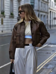 Detail view of vintage brown faux leather jacket featuring oversized cargo pockets and matte finish