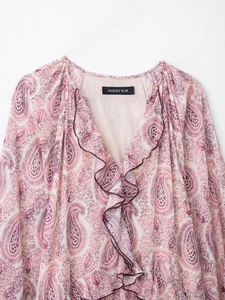 Detail of V-neckline with ruffle trim and pink paisley print on lightweight fabric