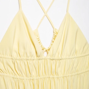 Elegant yellow backless slip dress with crossover straps and shirred waist detailing