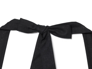 Detail shot of the black woven fabric knot and bow tie texture on the summer dress