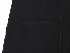 Détail de la poche passepoilée d'une combinaison noire avec texture de tissu et couture