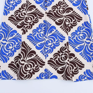 Detail of floral damask print dress with woven texture and brown buttons