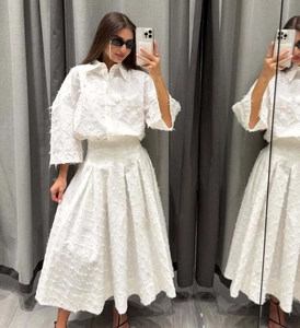 Détail de l'ensemble blanc deux pièces avec texture à franges et jupe plissée