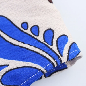 Macro view of blue printed fabric with white double stitching and linen texture details