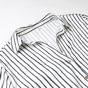 Close-up of a white striped shirt with gold buttons and size S label at the collar