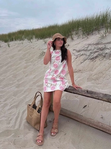 Close-up of pink floral prints on white sleeveless mini dress for summer beach vacation