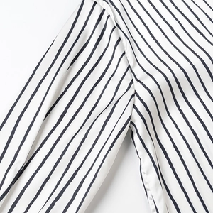 Detailed macro view of black and white vertical striped fabric with silky satin texture