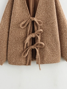 Nahaufnahme der camelfarbenen Fleecejacke mit feinen Schleifenverschlüssen und weichem Plüsch