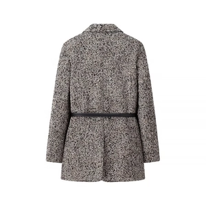 Close-up of herringbone tweed blazer with a slim black leather belt at the waist