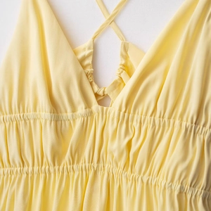 Élégante robe d'été jaune pâle avec col en V et fines bretelles croisées dans le dos