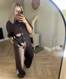 Dettaglio di un set in maglia marrone scuro con maglia a bottoni e pantaloni larghi