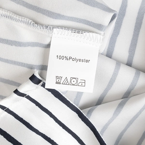 Close-up of the care label and 100% polyester fabric texture on a striped satin shirt