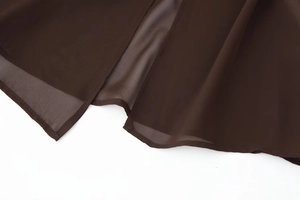 Detailed view of sheer dark brown chiffon fabric and neat hemline of the dress