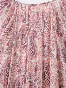 Detail of bohemian paisley print dress featuring an elastic ruffled neckline and fabric texture