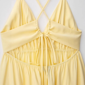 Robe dos nu jaune clair élégante avec bretelles fines et détails de laçage croisé