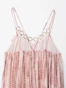 Detail of pink tie-dye pleated dress featuring gold metal ring neckline and thin straps
