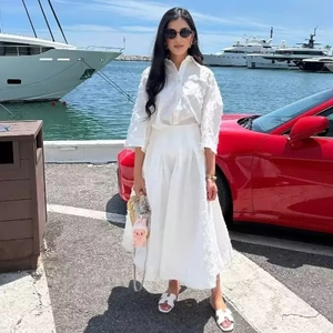 Ensemble élégant avec chemise à plumes et jupe plissée blanche pour un look de vacances