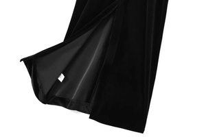 Detailansicht des hohen Seitenschlitzes an einem schwarzen Samtkleid mit Innenfutter