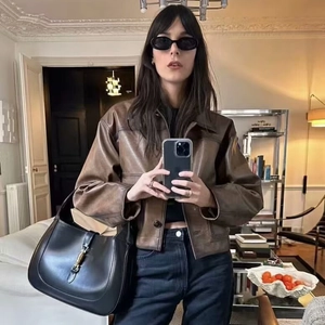 Women's vintage brown leather jacket with stylish black handbag in a mirror selfie outfit