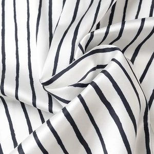Detailed view of the smooth satin fabric with elegant black and white vertical stripes
