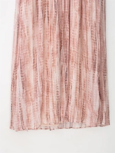 Detail of pink tie-dye pleated fabric showing delicate texture and fluid hemline