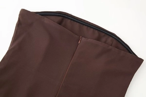 Detail of concealed zipper closure on waist of brown halter dress with clean stitching