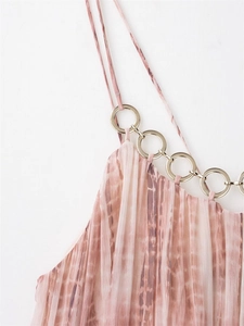 Close-up of pink tie-dye pleated dress featuring a gold chain metal ring strap detail