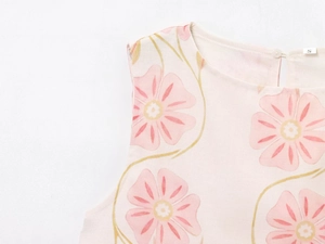 Close-up of beige floral mini dress fabric with round neckline and size S label