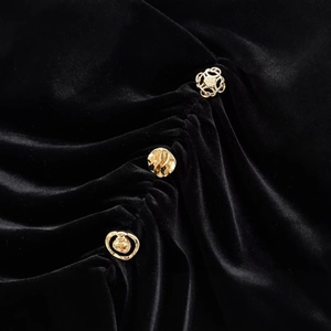 Elegantes schwarzes Samtkleid mit aufwendigen goldenen Vintage-Knöpfen als Detail