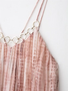 Detail of pleated tie-dye dress featuring a silver metal ring neck attachment