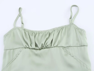 Detailed close-up of sage green satin camisole featuring gathered bust and adjustable straps