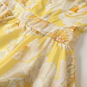 Detail of high waist pleats and yellow rose floral print on summer linen dress