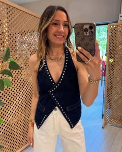 Detail view of denim halter top with silver rivets and unique crisscross front design