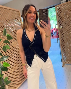 Detail of deep blue denim halter top featuring shimmering rhinestone and rivet trim edges