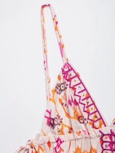 Detailed close-up of bohemian sequins and purple embroidery on tie-dye floral camisole