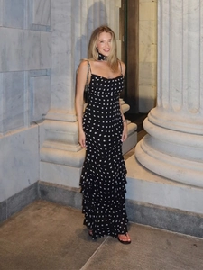 Detail of elegant black and white polka dot sleeveless maxi dress with tiered ruffle hem