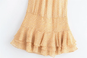 Dettaglio vestito floreale giallo con tessuto in chiffon leggero e orlo a balze sovrapposte