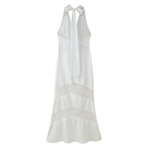 Detailed view of white backless maxi dress with delicate lace inserts and silk-like fabric