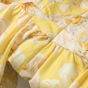 Detailed view of yellow floral chiffon fabric with delicate pleats and premium stitching