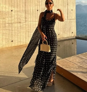 Detail of polka dot maxi dress featuring tiered ruffle hem and matching neck scarf