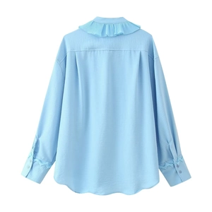 Vue arrière de chemise bleu clair avec volants superposés et nœuds aux poignets