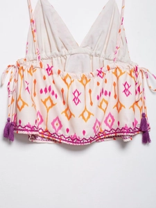 Detail of sequin flower embroidery and purple tassels on early spring camisole top