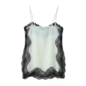 Detail der zarten schwarzen Blumenspitze an dem weißen halbtransparenten Camisole