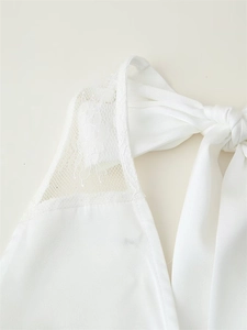 Close-up of elegant white floral lace stitching and bow-knot tie design on the neckline